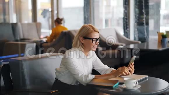 一位开朗的女企业家在网上打电话咖啡馆里挥舞着手视频的预览图