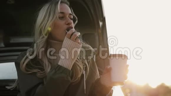 女人喜欢秋天喝热茶在车旁吃饼干视频的预览图
