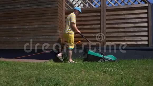 一名白人男子在自家后院割草万向节运动视频的预览图
