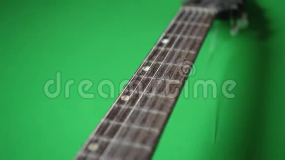 一把绿色地板上有断弦的古吉他视频的预览图