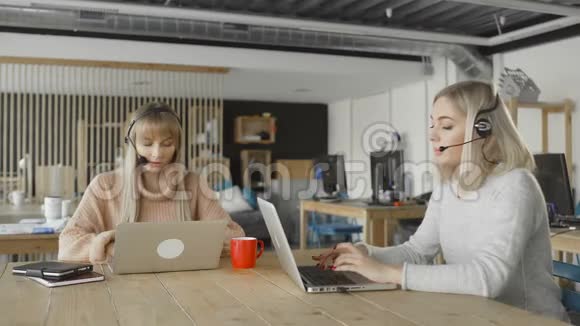 带麦克风耳机的女性通过电脑与顾客交谈妇女与个人电脑通过Skype沟通视频的预览图