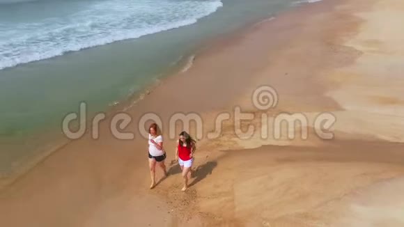 两个女孩在葡萄牙富拉多海滩散步视频的预览图