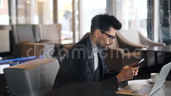 公司经理在咖啡厅使用现代智能手机专注于活动视频的预览图