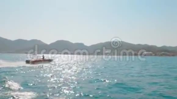 以山地和城市为背景在海上乘坐旅游充气管乘坐黄色充气船视频的预览图