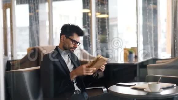 一个人坐在咖啡馆里读书翻页视频的预览图