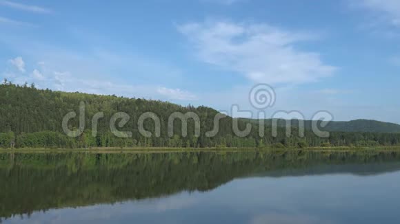 夏天阳光明媚的一天在河边蓝天平静的河山被森林覆盖自然景观环境安全4K视频视频的预览图