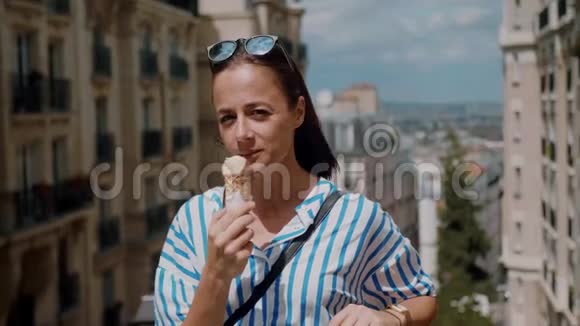 快乐的女孩在巴黎炎热的夏日舔冰淇淋视频的预览图