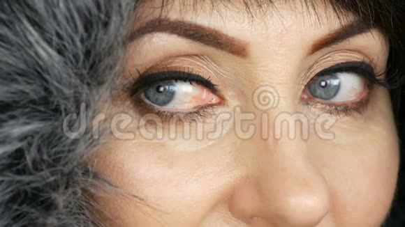 成年中年妇女美丽的蓝色大眼睛明亮的妆容彩绘箭头和假睫毛在人造毛皮视频的预览图