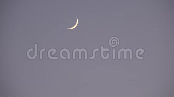 半月在云层中升起笼罩天空黄昏的光景黄昏的背景视频的预览图