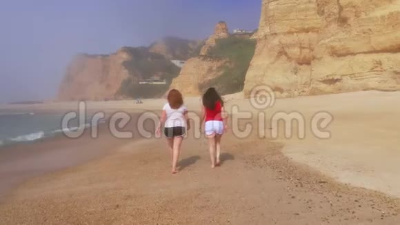 两个女孩在葡萄牙富拉多海滩散步视频的预览图
