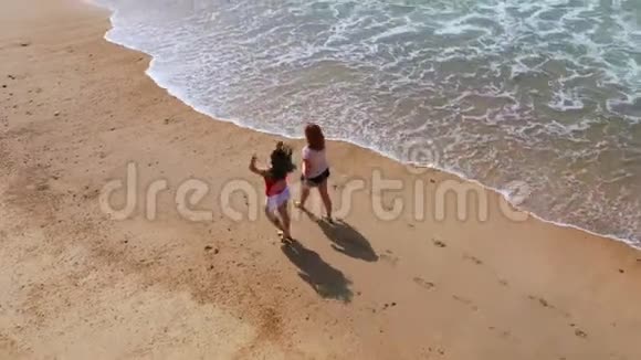 在葡萄牙沙滩上跑步两个女孩在度假视频的预览图