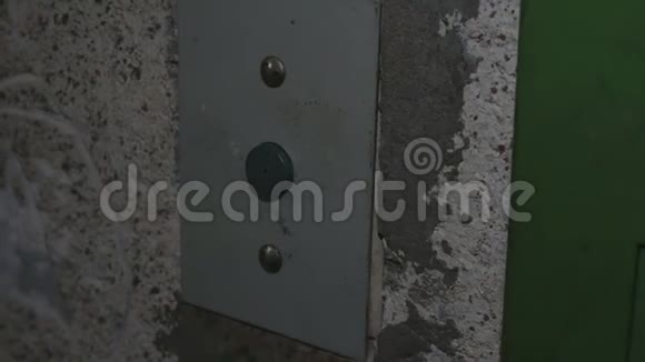 女人晚上按一个旧的电梯按钮上去旧金属电梯手指用箭头按按钮视频的预览图