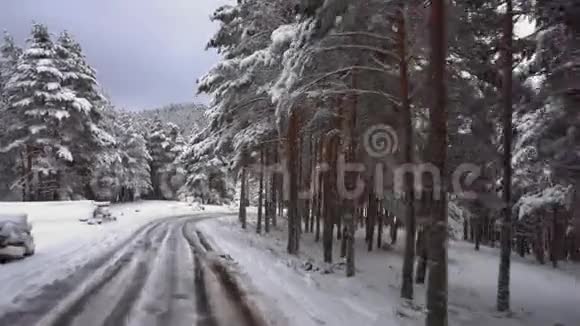 行驶在积雪覆盖的山林道路上波夫在一座雪覆盖的山的道路上行驶的稳定摄像机镜头视频的预览图