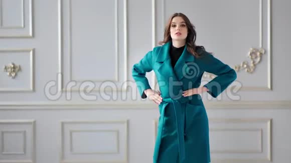 美丽的时装模特展示时髦的秋色大衣摆在现代豪华工作室视频的预览图