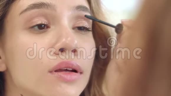 漂亮的女人用黑色睫毛膏涂睫毛前卫浴镜视频的预览图