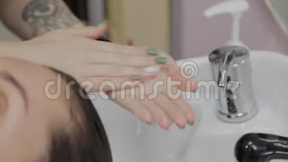 女理发师把洗发水放在手上视频的预览图