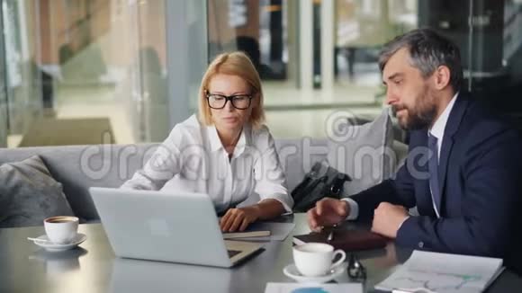 成熟的商务女士和留胡子的男人讨论信息视频的预览图