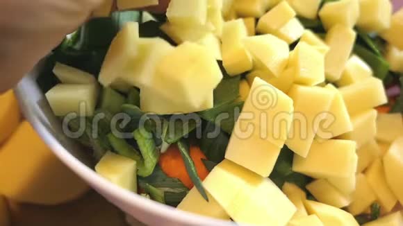 把生土豆片和其他汤料放进碗里视频的预览图