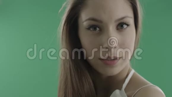 性感的年轻女人在绿色的背景下用一头松发抚摸自己视频的预览图