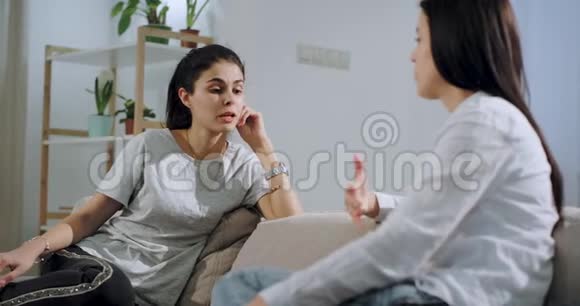两个成熟的姐妹一起在沙发上亲密交谈他们在宽敞的客厅里集中交谈视频的预览图