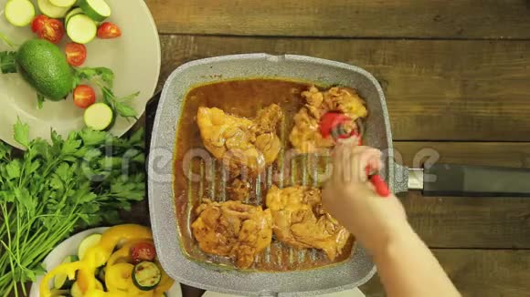 女人手用钳子把鸡块放在烤盘里视频的预览图