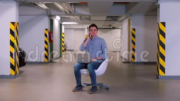 一个男人坐在地下车库的椅子上视频的预览图