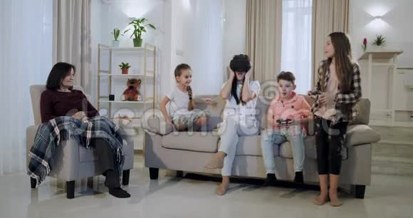 一个有三个孩子的大家庭妈妈和奶奶在一起玩电子游戏玩得很开心妈妈用虚拟现实视频的预览图
