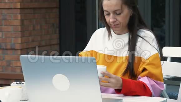 年轻女人用手提电脑喝咖啡视频的预览图