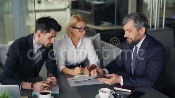 商务人士分析午餐期间在咖啡馆工作的财务文件视频的预览图