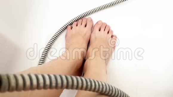 女性腿在湿白色浴缸与软管和水流视频的预览图
