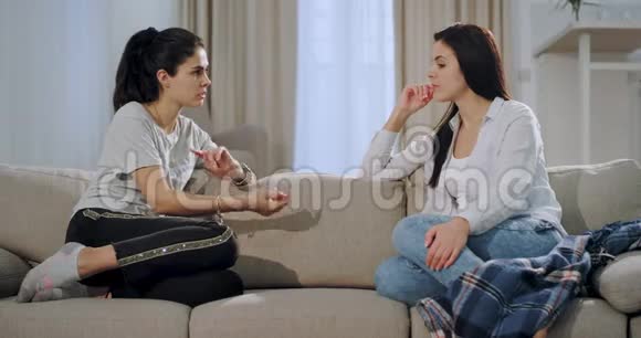 好朋友两位有魅力的女士坐在沙发上在一起玩她们在一起聊天视频的预览图