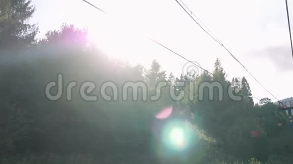 在蓝天和阳光的映衬下在绿林和山林中的松树之间架设钢索视频的预览图