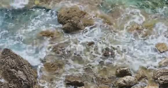 青绿色的海浪拍打着石岸自然背景视频的预览图