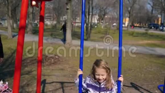快乐摇摆儿童户外可爱的女孩有乐趣在公园里上下摇摆无忧无虑的童年视频的预览图