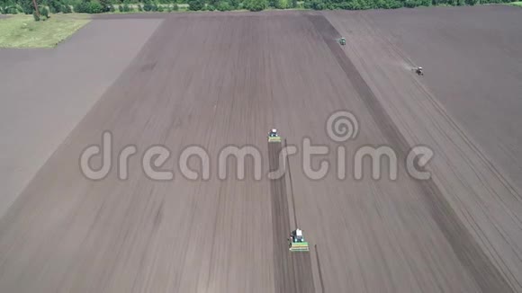 用4台工作拖拉机在一片灰色的田野上飞行空中景观视频的预览图