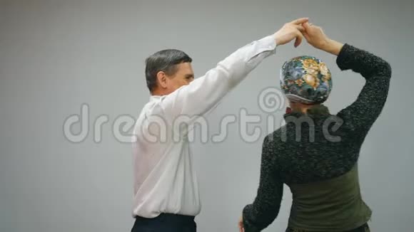 一对老年夫妇正在白色背景上跳华尔兹视频的预览图