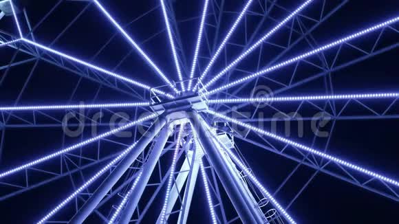 游乐园里五颜六色的闪烁摩天轮在晚上围绕着它的轴线旋转夜间游览景点视频的预览图