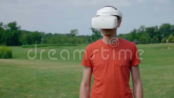 一个男人在公园里用VR耳机把头转向右边视频的预览图