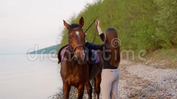 河岸上的女孩准备骑马视频的预览图