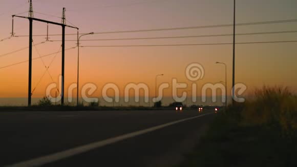 在黎明公路上驾驶带大灯的汽车视频的预览图