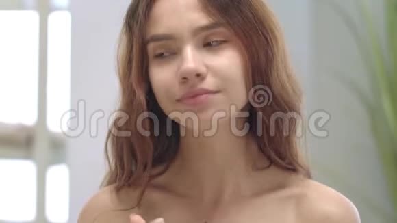 肖像年轻女子在浴室里涂化妆霜清洁皮肤模型视频的预览图