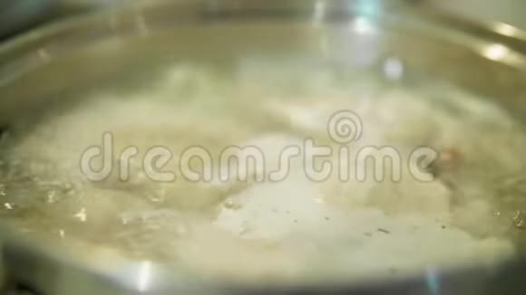 厨师把饺子和木勺混合在锅里视频的预览图