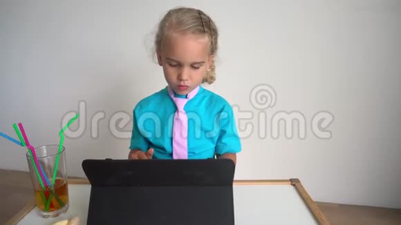 严肃可爱的女孩在玩商业女办公室职员坐在平板电脑上视频的预览图