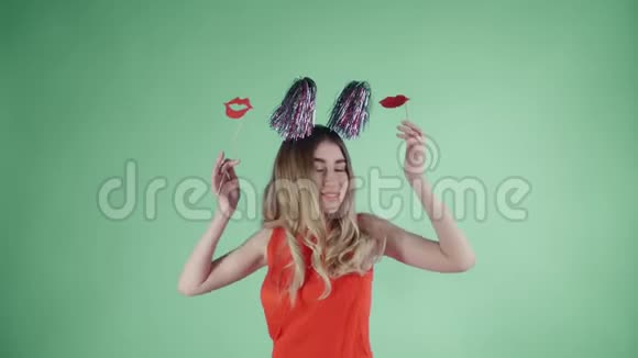 戴着派对帽的漂亮女孩正在绿色背景下的肥皂泡下跳舞视频的预览图