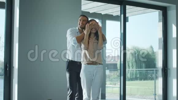 快乐的男人闭上眼睛女人在新家幸福的妻子享受豪华的房子视频的预览图