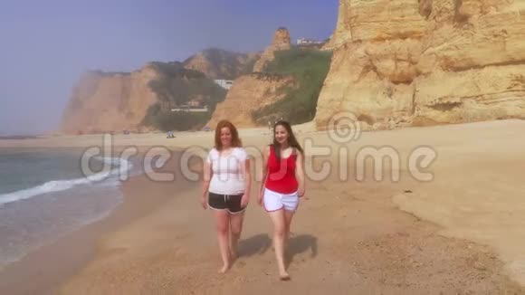 在葡萄牙沙滩上跑步两个女孩在度假视频的预览图