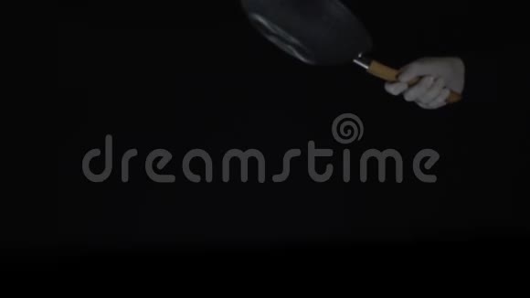 厨师在用黑底锅煮的食物中加入盐侧视图视频的预览图