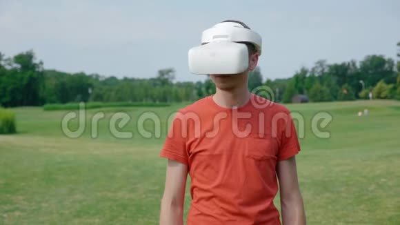 一个男人在公园里用VR耳机把头转向右边视频的预览图