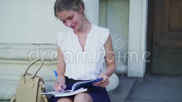高等教育幸福女孩女学生坐在大学台阶上视频的预览图