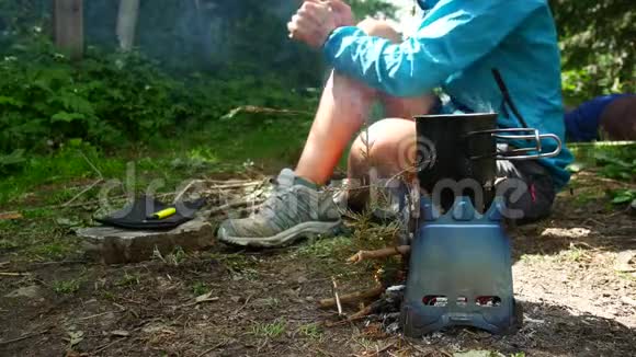 女孩在一个杯子里的露营炉子上准备茶视频的预览图